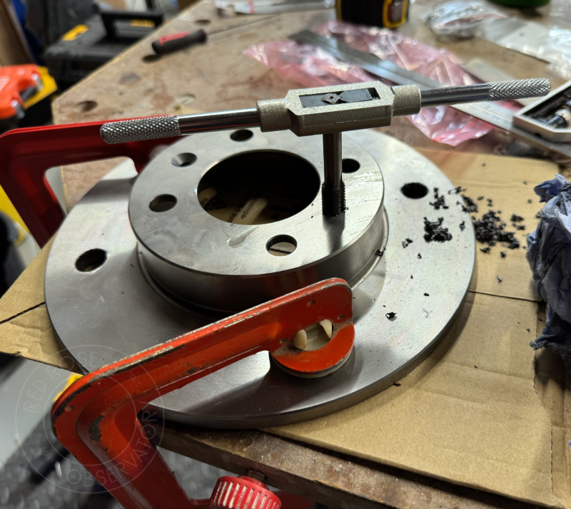 Tapping a thread in the azimuth post mounting hole to allow a bolt to be fitted.