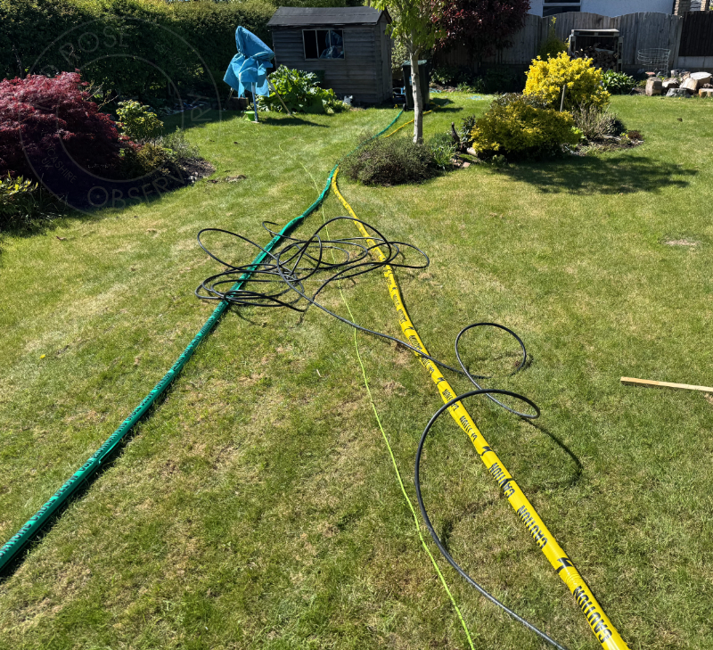 The two ducts that I wanted to bury to feed the observatory, plus a tangled mess of cable ready to be threaded through. Green for data, yellow for power. Also notice the covered-up telescope at the back near the shed, that's where I plan for the observatory to go.